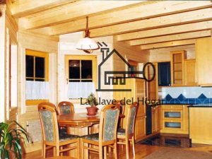 comedor y cocina en vivienda de madera con vigas vistas