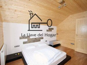 dormitorio de matrimonio en casa de madera con pared del cabezal en obra