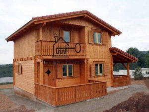 casa de madera de 2 pisos con terraza delantera y porche lateral