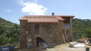 Reformando la cubierta de una masía colocando nuevas tejas sobre rastreles de madera